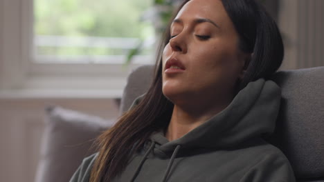 anxious woman sitting indoors on chair working from home using laptop worried about cost of living crisis