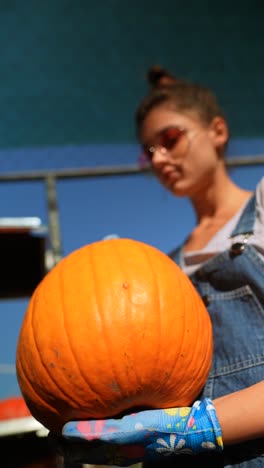 woman holding a large pumpkin