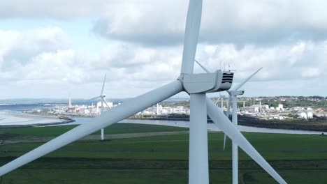 Alternative-green-energy-wind-farm-turbines-spinning-in-Frodsham-Cheshire-fields-aerial-rear-view-closeup