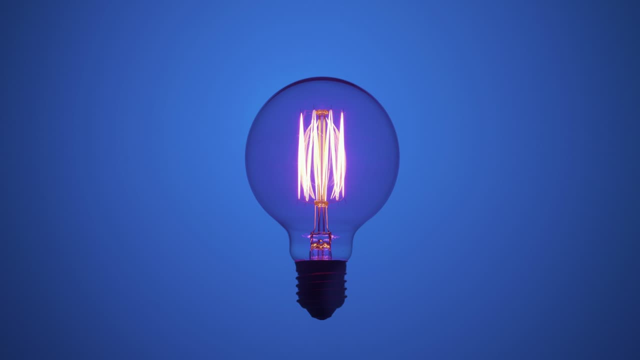 una bombilla de tungsteno parpadeando sobre un fondo de luz azul.