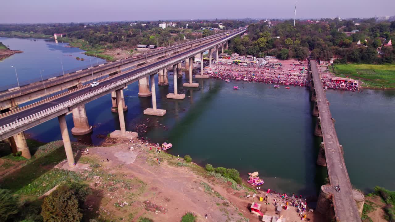 holy bath with Tilwara Narmada River Bridge at Narmada Ghat, Jotpur, Jabalpur, Madhya Pradesh, india. day time, semi orbit, drone shot, 4k.