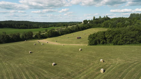 Erstellen-Einer-Luftaufnahme-Eines-Mit-Heuballen-Geernteten-Landwirtschaftlichen-Feldes-Mit-Einem-Traktor