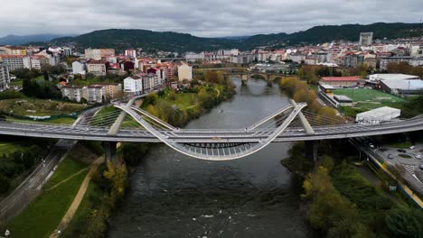 Grasgrüne-Rasenflächen-Und-Römische-Brücke-Hinter-Der-Millennium-Brücke-Am-Fluss-Miño-In-Ourense,-Galizien,-Spanien