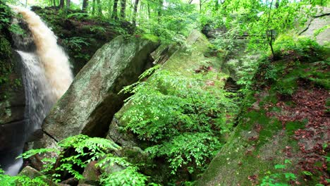 a cinematic view of cascade falls among leaves and moss covered boulders in nelson ledges state park on a beautiful autumn day