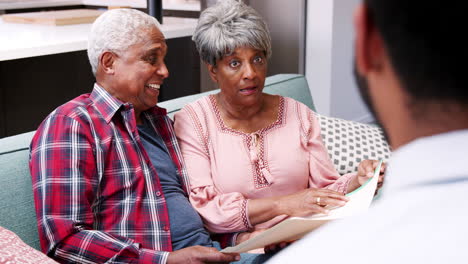 senior couple meeting with male financial advisor at home