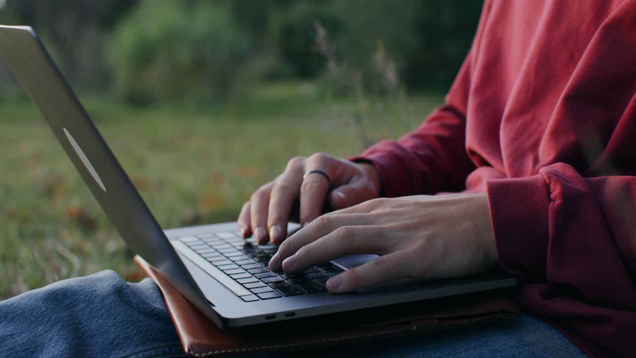 persona que trabaja con una computadora portátil al aire libre