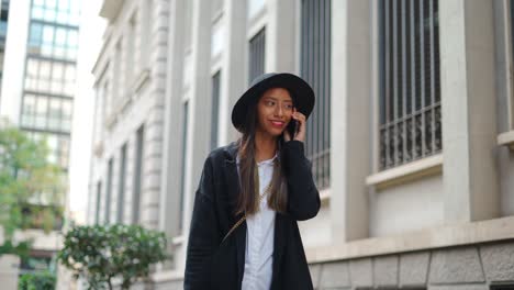 stylish hispanic woman talking on smartphone