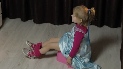 little girl sitting on the potty and watching tv