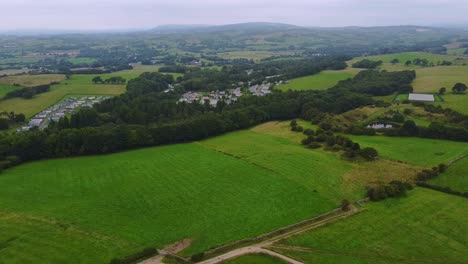 Aerial-pan-of-distant-caravan-park-in-UK-countryside-on-cloudy-day