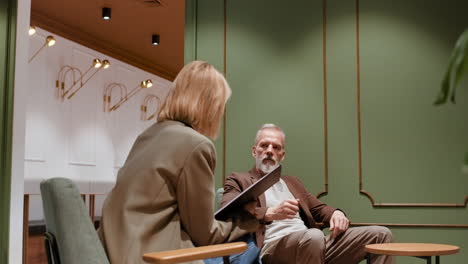 two professionals engaged in a serious discussion in a modern office lounge
