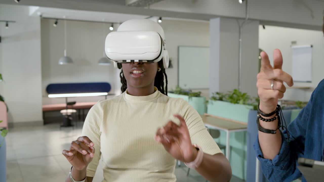 Et afroamerikansk team demonstrerer VR på et kontor, hvor en kvinde udforsker, efter at en kollega har trykket på en tablet.
