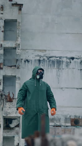 human in biohazard uniform standing in the empty city. man in protective mask and suit. vertical video
