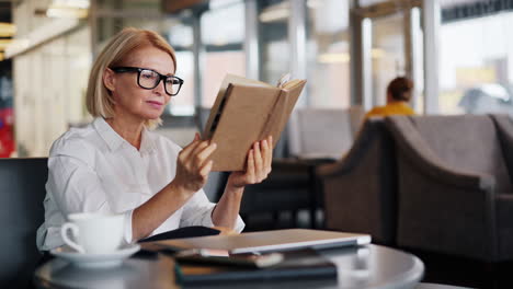 woman reading a book in a coffee shop