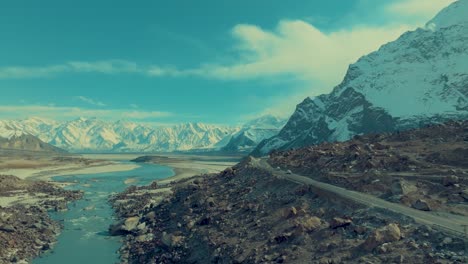 Aerial-pullback-view-of-Skardu-landscape-of-snow-covered-mountains-at-background-and-highways-leading-to-mountains-in-foreground-in-Pakistan