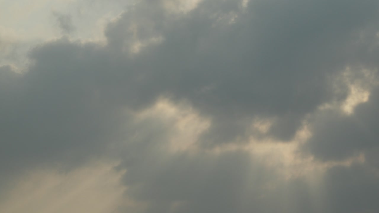 Dramatic clouds and sun rays breaking through sky over, natural backdrop