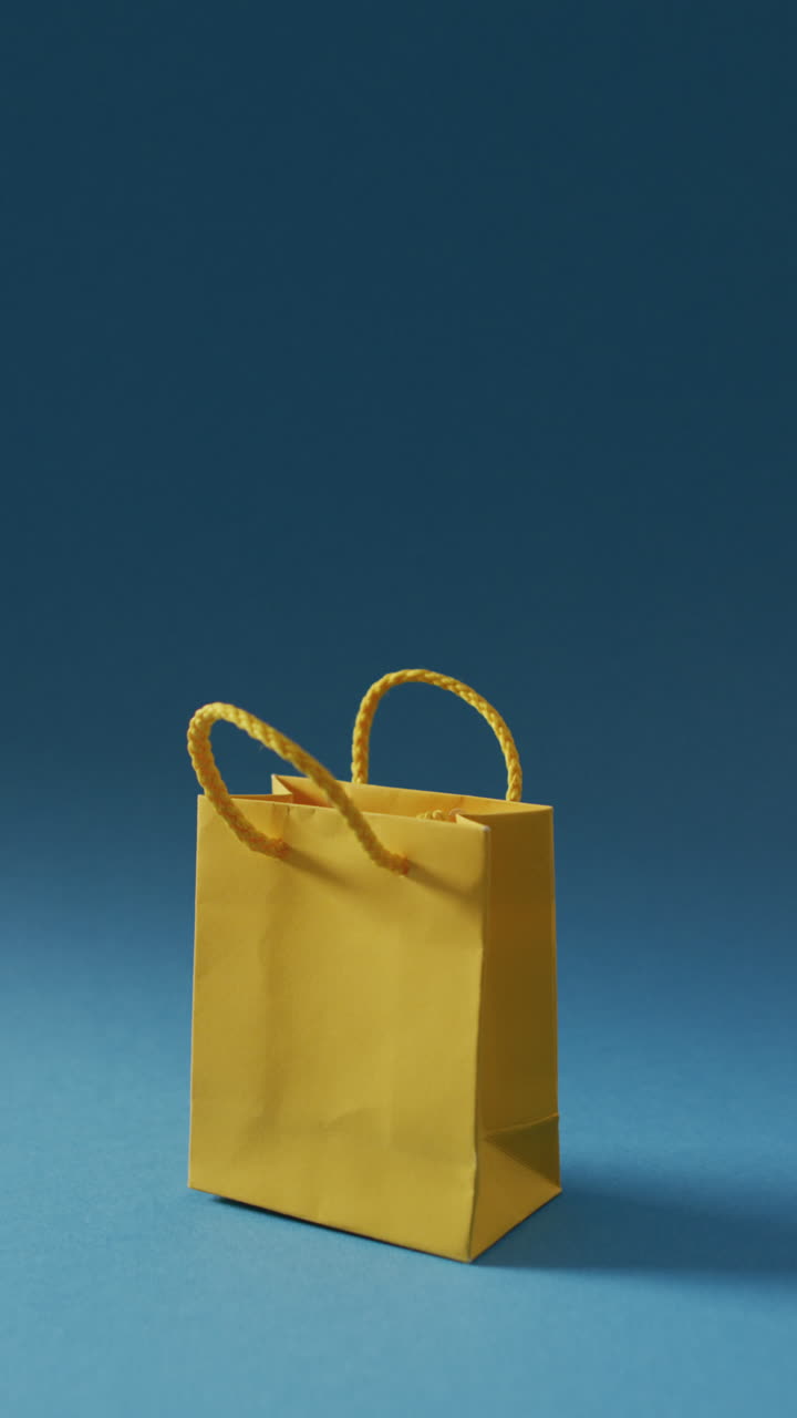 video vertical de una bolsa de compras de papel sobre un fondo azul