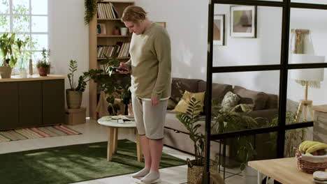 Young-man-with-smartphone-on-her-bedroom