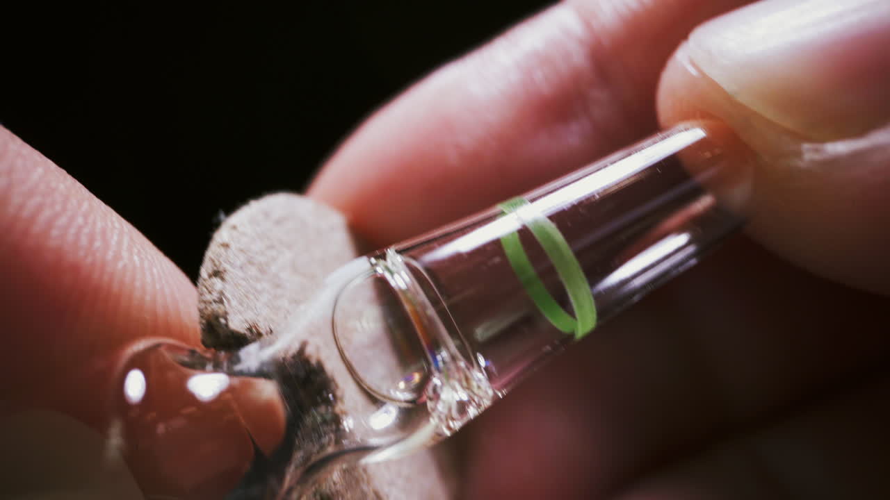 el médico usa un cortador para abrir una ampolla de vidrio con un medicamento antiviral