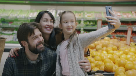 happy family taking a selfie in a grocery store