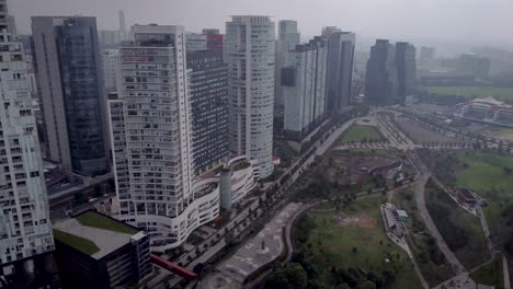 Shot-walking-away-from-group-of-buildings-at-the-side-of-La-Mexicana-park-in-western-Mexico-City-on-a-foggy-day