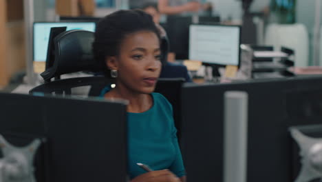 mujer de negocios afroamericana trabajando con un colega en una oficina ocupada equipo de ventas corporativo colaborando en un proyecto financiero para la estrategia de la compañía