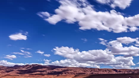 blue sky and fluffy clouds above desert area, fusion time lapse