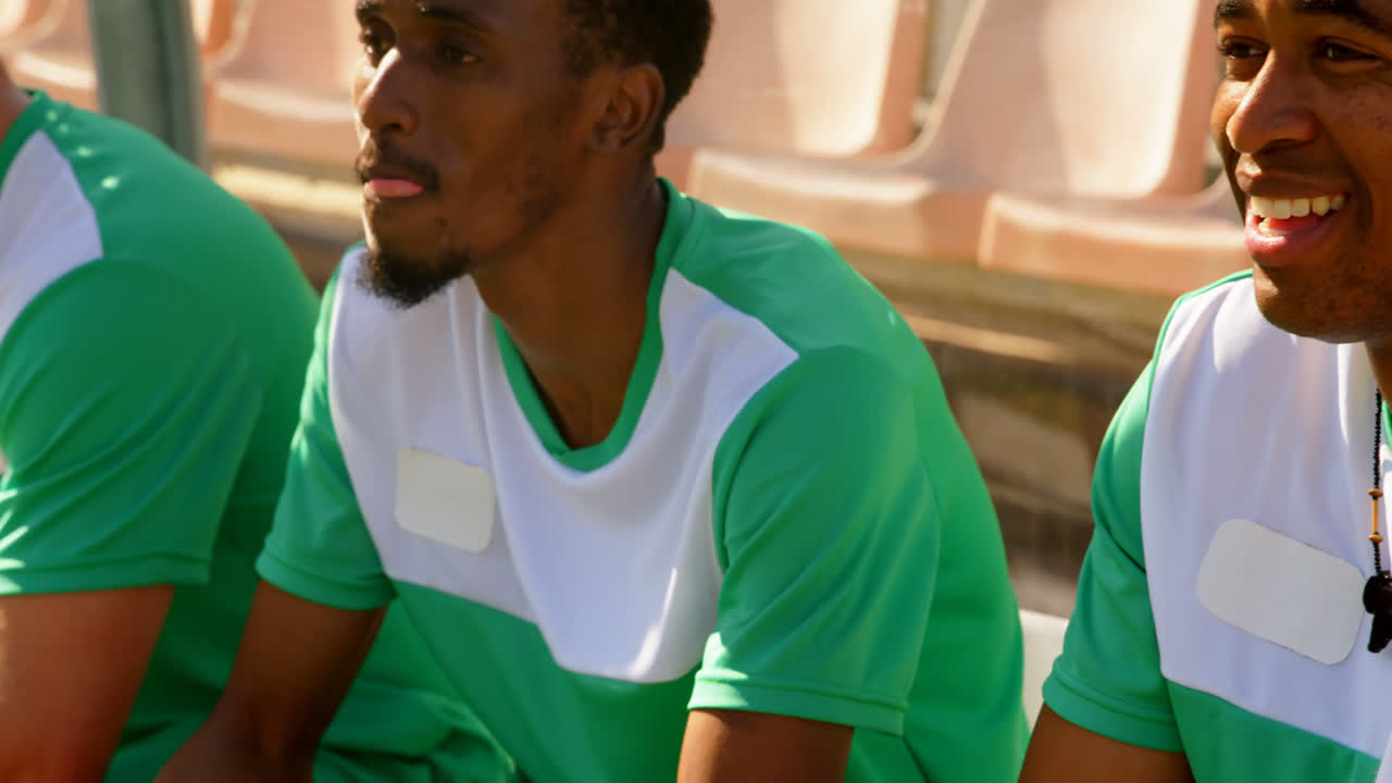 jugadores de fútbol esperando en el estadio 4k