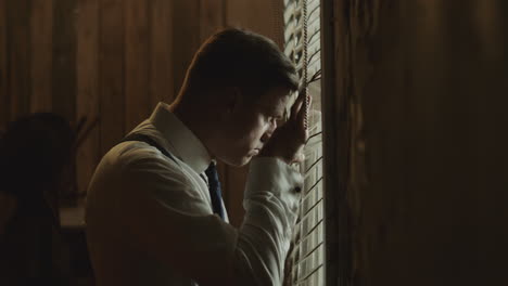 man looking through window in a vintage interior