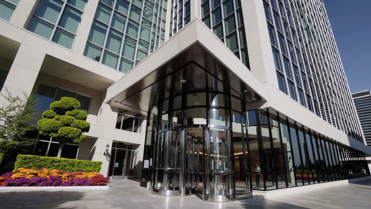 Wide-angle video shot of a hotel's revolving doors, capturing a modern, sleek entrance