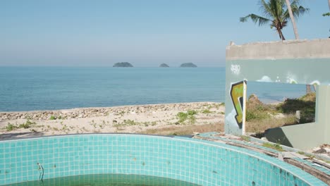 Tiro-Inclinado-Hacia-Arriba-De-Una-Piscina-Vacía-En-Un-Complejo-De-Bungalows-De-Playa-Abandonado-En-La-Isla-De-Koh-Chang-En-Tailandia