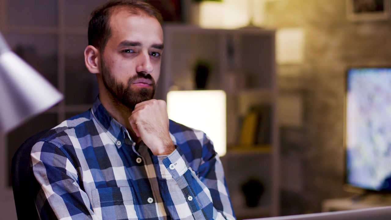 Focused Man Working on Laptop in Home Office at Night