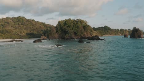 antena cinemática de drones volando bajo sobre el agua una playa en costa rica