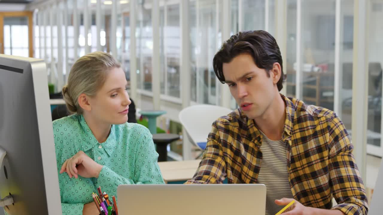hombre y mujer jóvenes trabajando en una oficina creativa