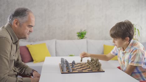 el abuelo y el nieto están jugando al ajedrez.