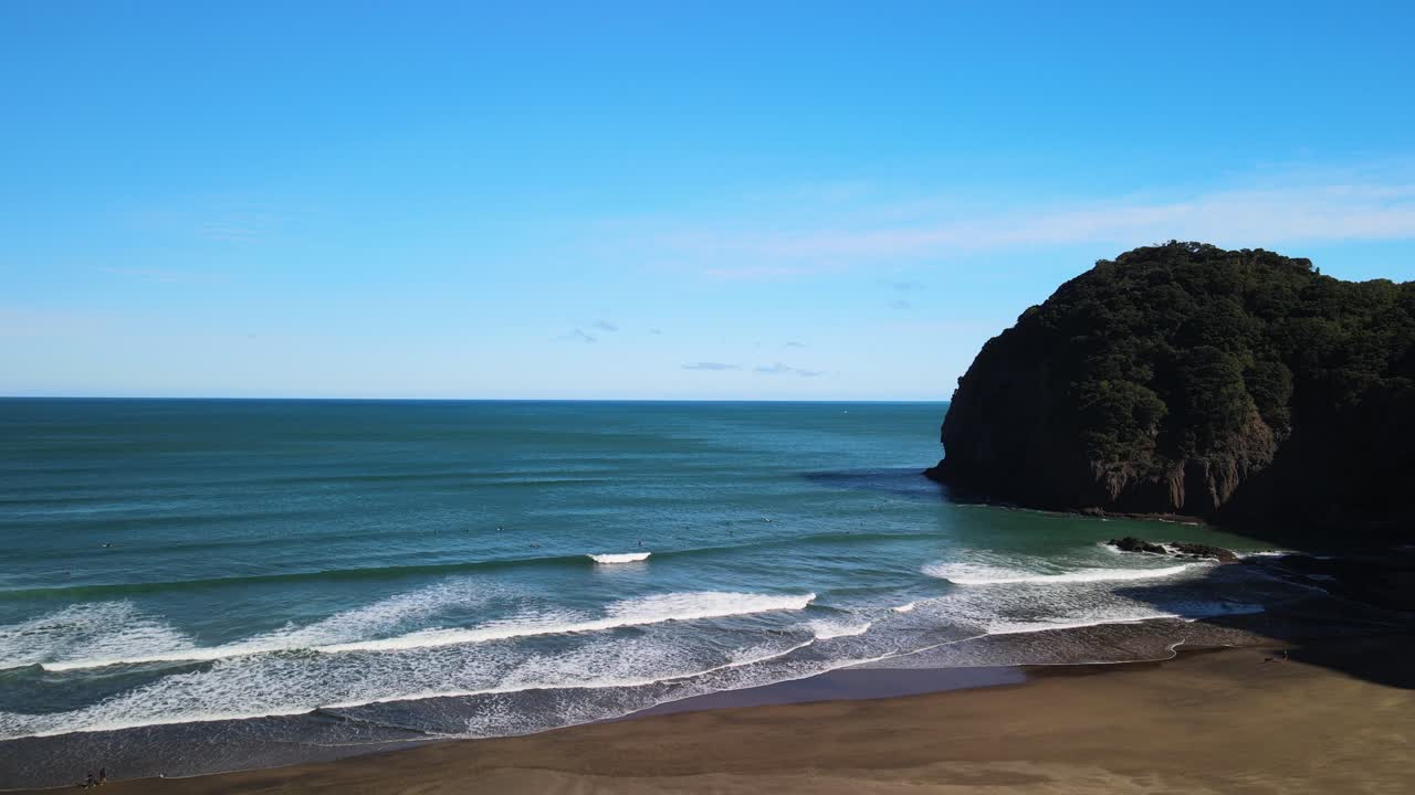 Guardando il surf di livello mondiale sulla spiaggia di sabbia nera di Piha, Nuova Zelanda
