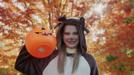 a child with a basket in the form of a pumpkin to collect sweets. halloween is a traditional autumn holiday