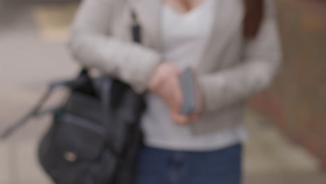 close up of stressed and anxious woman outdoors with financial worries about cost of living crisis checking empty money purse on city street