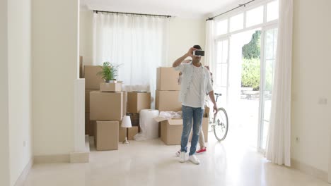 Young-man-trying-out-VR-goggles-guided-by-his-wife