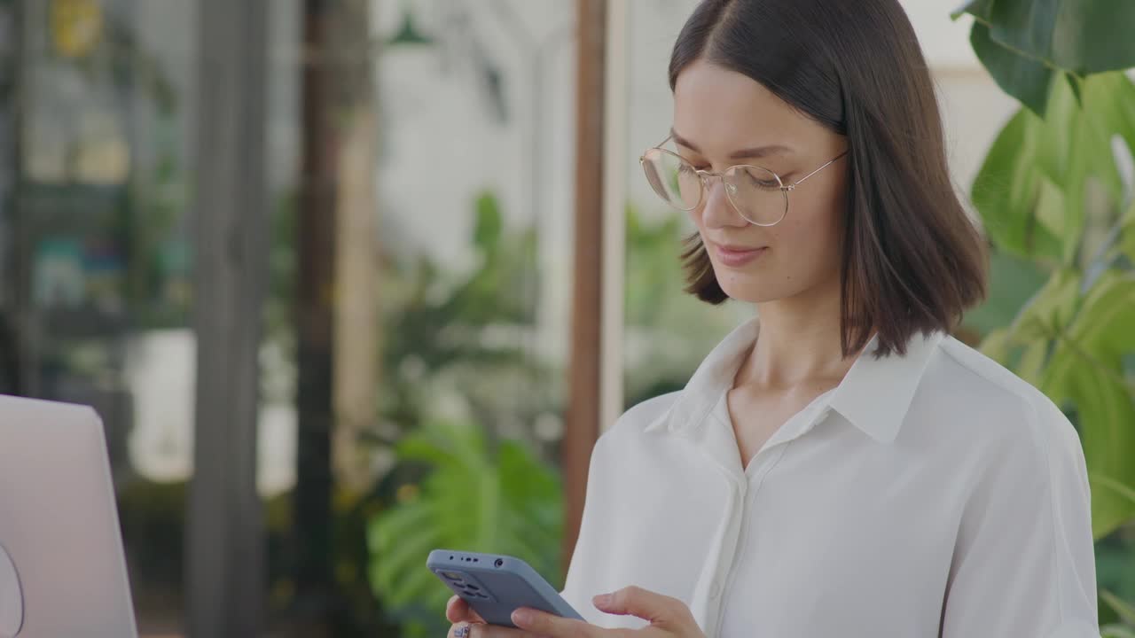 Businesswoman Using Phone in Outdoor Coffeeshop