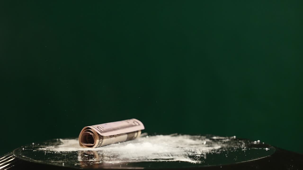 harina y billete retorcido en un subwoofer móvil sobre un fondo verde