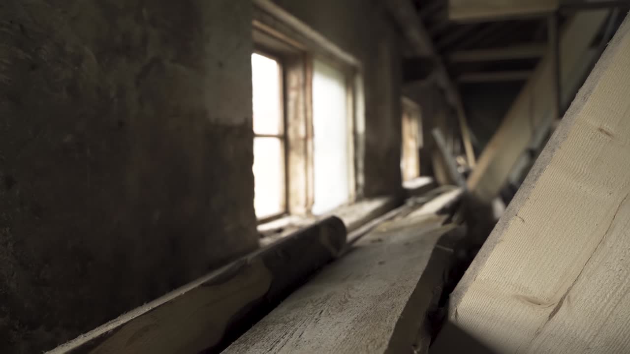 Sunlight Passing Through Glass Window Of An Old Shed With Pile Of Timber Inside. - wide shot