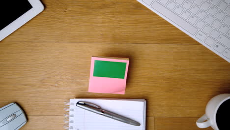 Pink-sticky-notes-with-chroma-key-falling-onto-office-desk