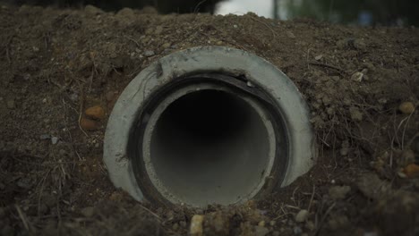 sewer pipe hole in the street near road during sunny afternoon in france. concrete tube. 4k uhd.