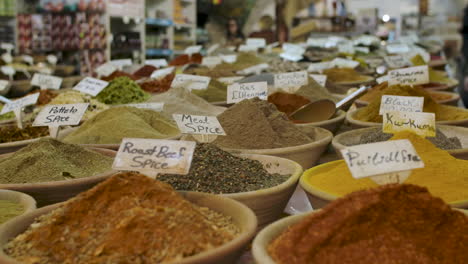 many different spices for sale inside bowls at a local shop, each for a specific dish