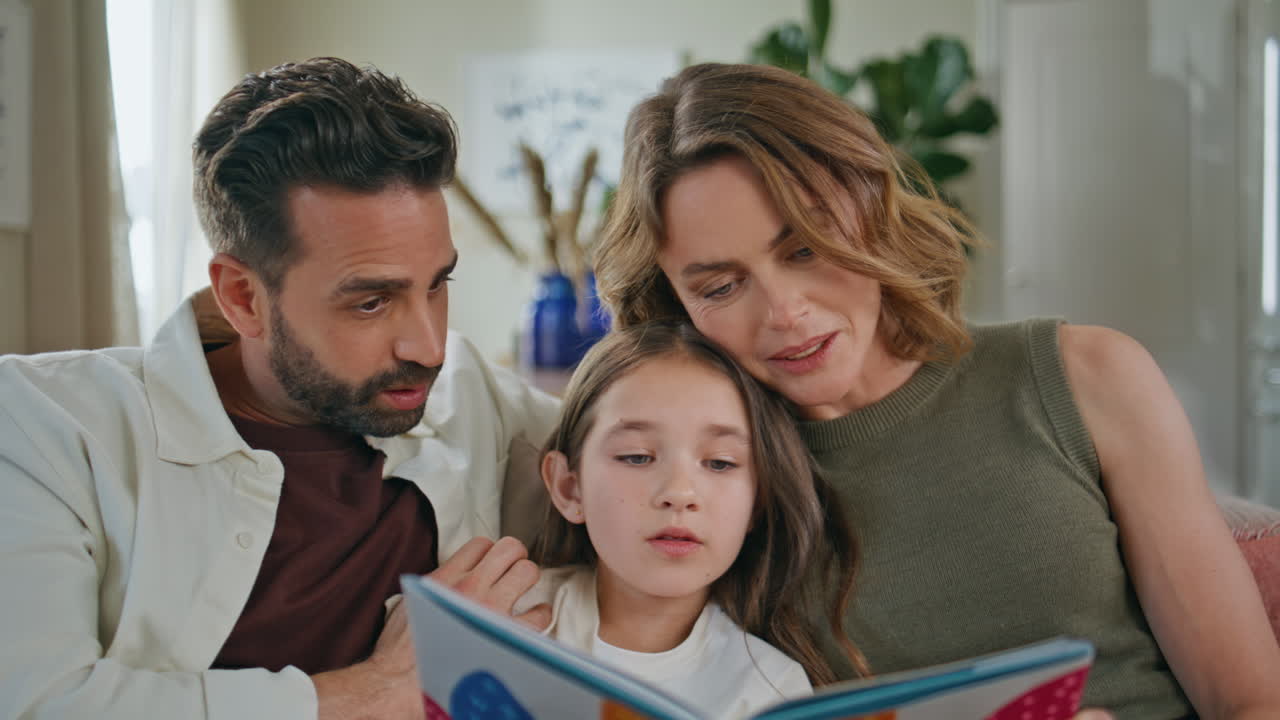 Primo piano di una famiglia unita che legge un libro di fiabe e trascorre del tempo libero in una casa accogliente