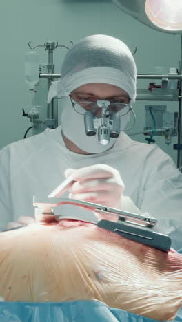el cirujano gira la palanca retractora para expandir la incisión. el cardiólogo abre el acceso al corazón enfermo con herramientas para la cirugía de bypass de la arteria coronaria en la clínica