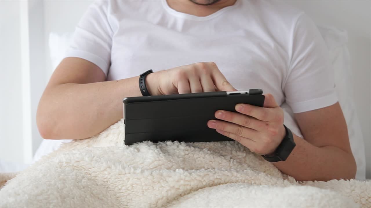 Man using a tablet in bed