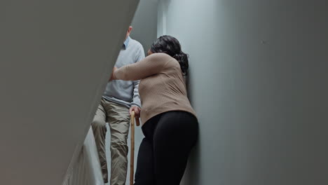 caregiver assisting senior man on stairs