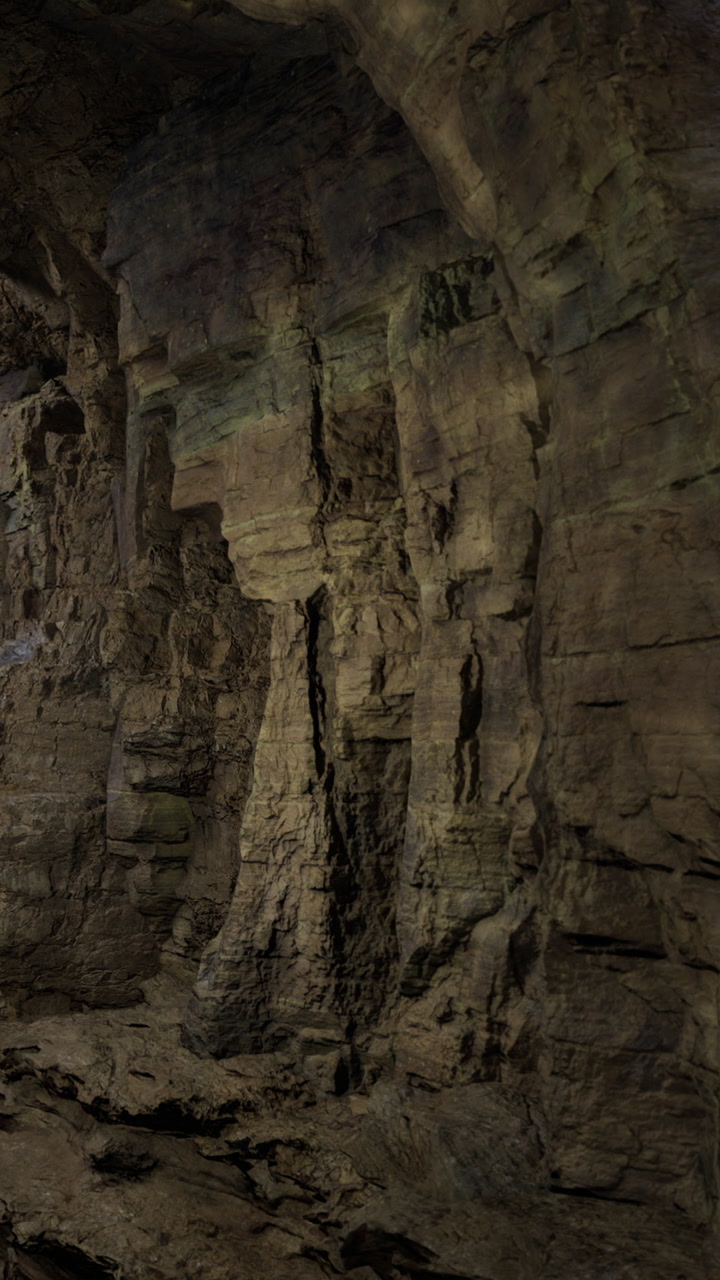 Exploring a rocky cave with unique formations and shadows at night