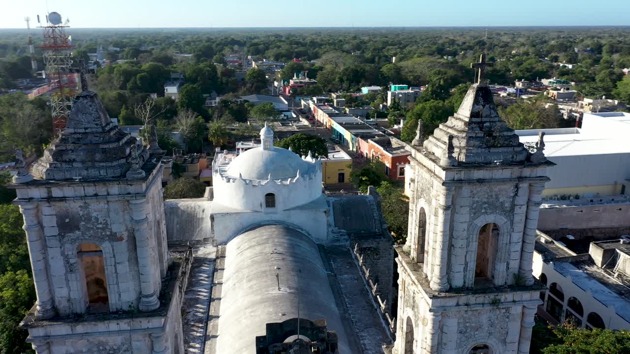 Aerial extreme closeup orbit to left of the bell towers of the Catedral de San Gervasio in Valladolid, Yucatan, Mexico just after sunrise